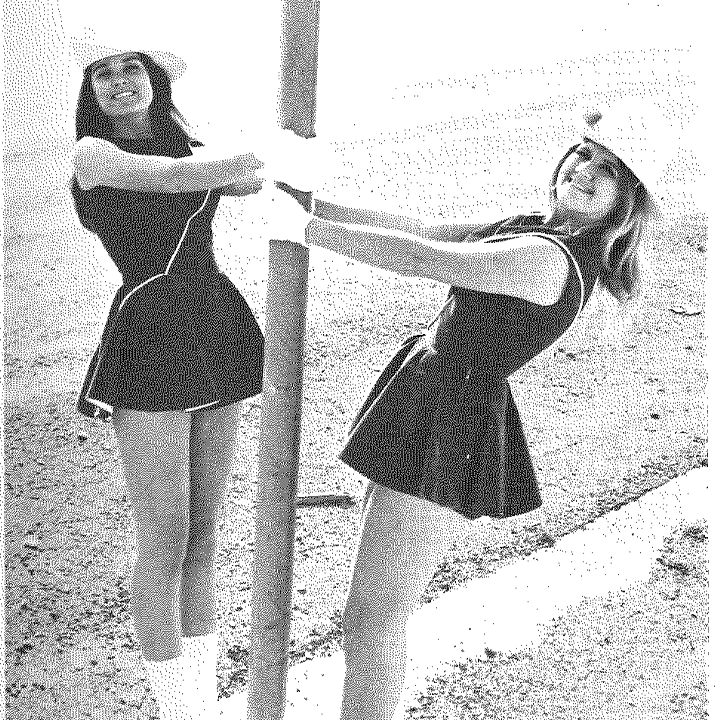 Cheerleaders hanging on sign